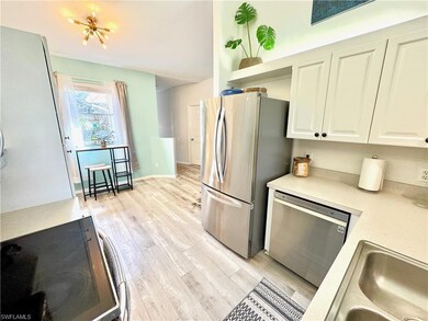 Kitchen with white cabinetry, appliances with stai