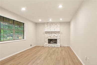 Unfurnished living room with light wood-type flooring, a fireplace, and recessed lighting