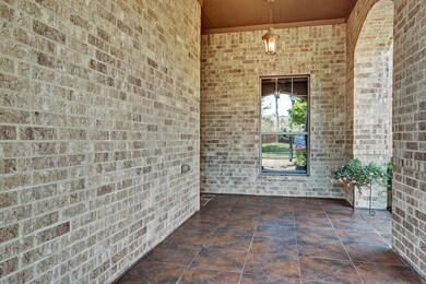 Enjoy morning coffee on this extended tiled entrance that leads to the front entry