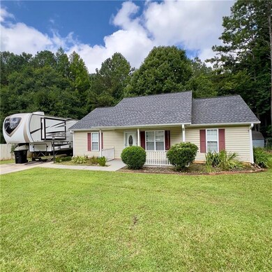Single story home with roof with shingles, covered porch, and a front yard