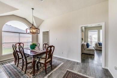 Dining area featuring a notable chandelier, dark hardwood / wood-style floors, a textured ceiling, and vaulted ceiling