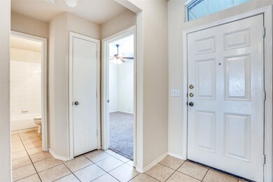 Foyer entrance with ceiling fan, baseboards, and 