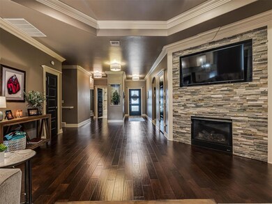 Living room featuring a stone fireplace, dark wood