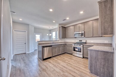 The kitchen highlights elegant granite countertops, complemented by vinyl plank flooring and 42-inch overhead cabinets that offer ample storage space for all your kitchen essentials.