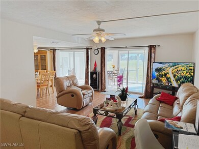 Living room featuring ceiling fan, light hardwood