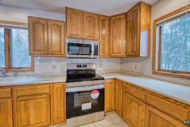 Kitchen featuring tasteful backsplash, light tile 