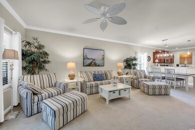 Living area featuring crown molding, light colored carpet, a chandelier, and a ceiling fan