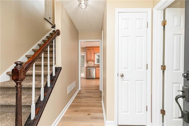 Main Front entry to home, freshly painted throughout, staircase to 2nd floor on left, hallway closet, 1/2 bath on right, and laundry room ahead on right, and kitchen entry.