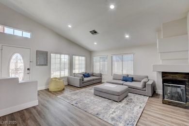 Living room featuring high vaulted ceiling, basebo