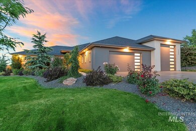 View of front of house with an attached garage, driveway, a front lawn, and roof with shingles