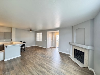 Living area featuring a tile fireplace, baseboards