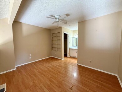 Empty room featuring ceiling fan, a textured ceil