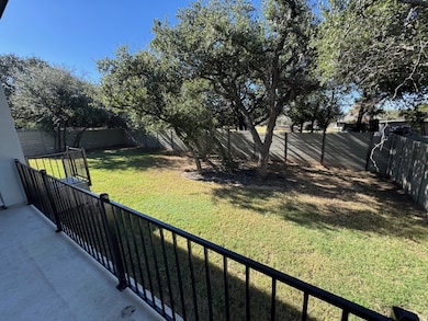Fenced backyard featuring a balcony