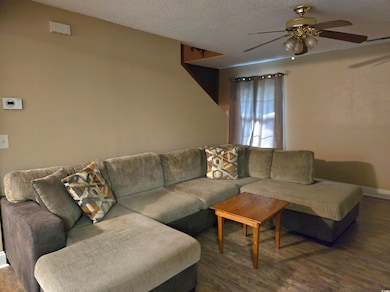Living room with a textured ceiling, ceiling fan, 
