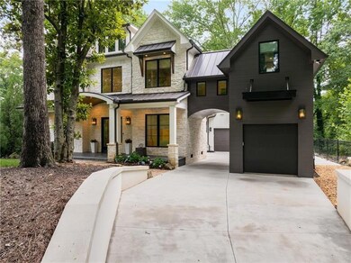 View of front of house with a standing seam roof, a porch, concrete driveway, an attached garage, and stone siding
