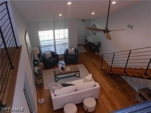 Living room featuring ceiling fan and hardwood / w