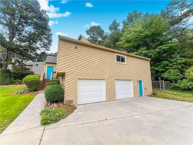 View of property exterior featuring a garage and driveway