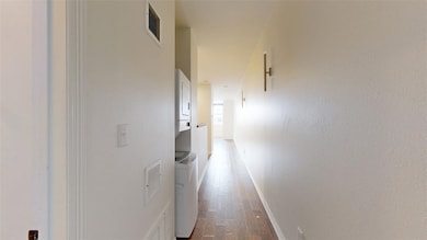 Hallway featuring baseboards, visible vents, stack