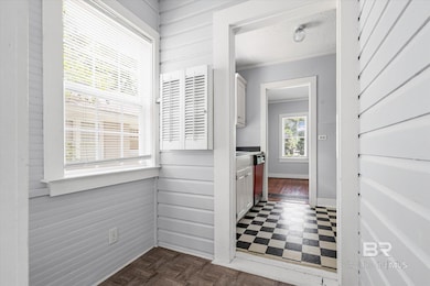 Hallway featuring wood walls, crown molding, dark floors, and a textured ceiling