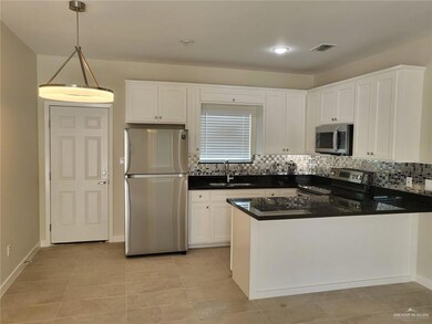 Kitchen with stainless steel appliances, a sink, dark countertops, and backsplash