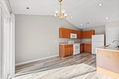 Kitchen with sink, hanging light fixtures, a notab