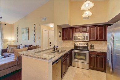 The kitchen features rich, dark cabinets, granite 
