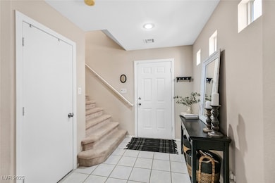 Entrance foyer featuring stairway, light tile patt
