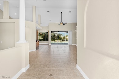 Hallway featuring light tile patterned floors, high vaulted ceiling, arched walkways, and a sunroom