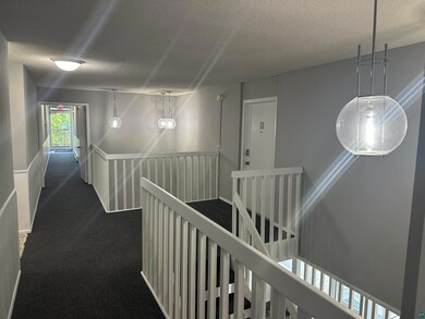 Corridor with dark carpet and a textured ceiling