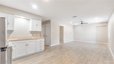 Kitchen featuring light countertops, freestanding refrigerator, white range oven, white cabinetry, and ceiling fan