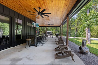 The front porch features wood-beamed ceilings, fan