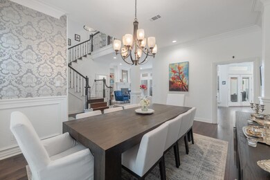 Dining space featuring a towering ceiling, a chandelier, dark hardwood / wood-style floors, and ornamental molding