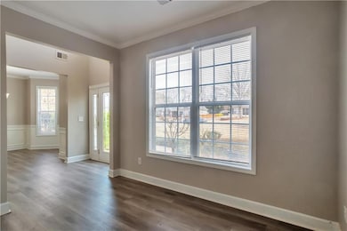 Spare room featuring dark wood-style floors, visib