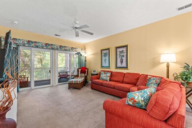 Carpeted living room with a ceiling fan and a text