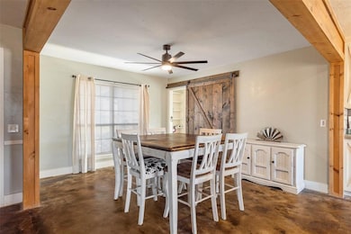 Dining area with ceiling fan and a barn door