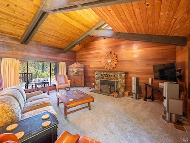 The Living Room has a beautiful stone fireplace complimented by the lovely wood interior.