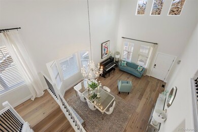 Aerial view of the great room and dining area, highlighting soaring ceilings, transom windows, and expansive natural light.