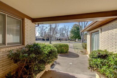 Covered entrance with brick landscaping boxes on b