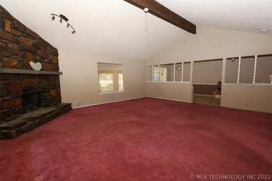 Living area with stone fireplace and vaulted ceili