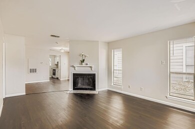 Unfurnished living room featuring dark wood-style floors and a fireplace with flush hearth