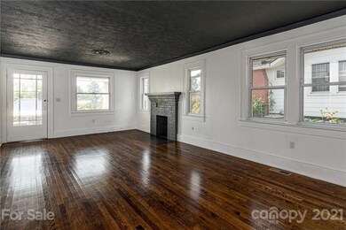 Open living room with refinished floors and unvented gas fireplace
