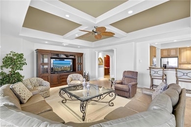 Living room featuring coffered ceiling, beam ceiling, recessed lighting, decorative columns, and a ceiling fan