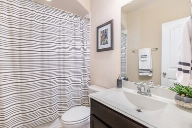 The secondary bathroom offers a large countertop and a combination  shower/tub.
