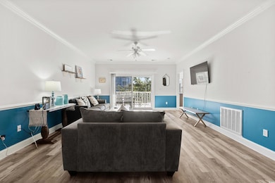 Living room featuring crown molding, ceiling fan, 