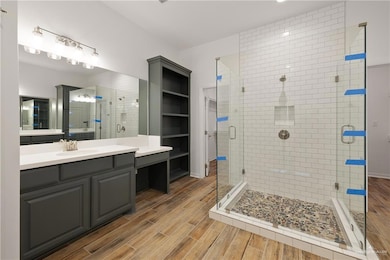 Full bathroom featuring wood finished floors, a stall shower, and vanity