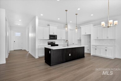 Kitchen with white cabinets, decorative backsplash, a kitchen island with sink, decorative light fixtures, and recessed lighting
