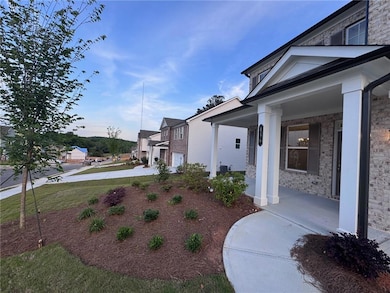 View of side of property with a porch and brick siding