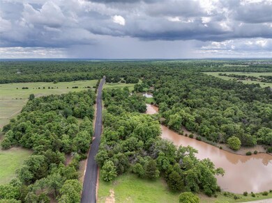 Drone / aerial view of a large body of water and a heavily wooded area