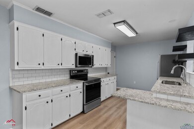 Kitchen with sink, backsplash, white cabinetry, an