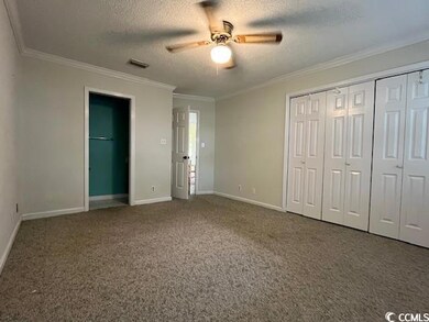 Main bedroom with a textured ceiling, ceiling fan,